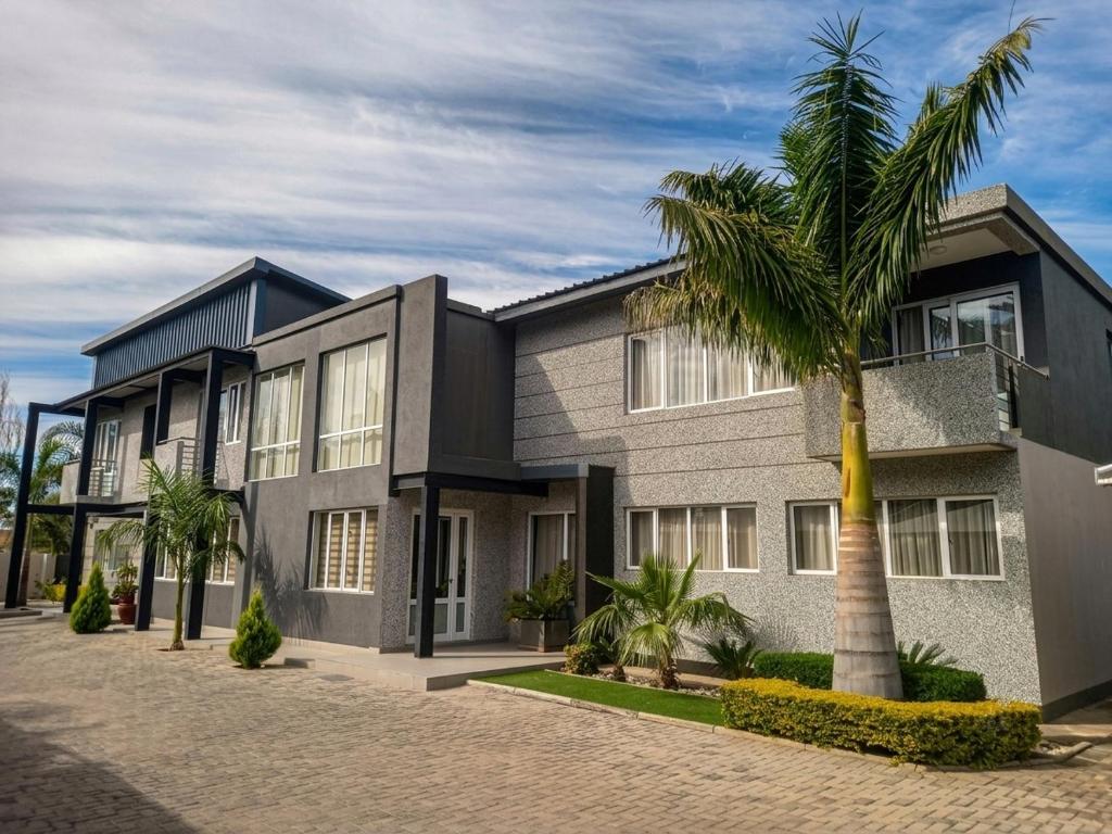 a building with a palm tree in front of it at Cycad Palm Hotel in Gaborone