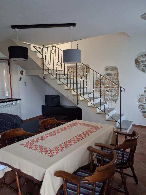 a room with a table with chairs and a staircase at Il Borghetto in Castano Primo