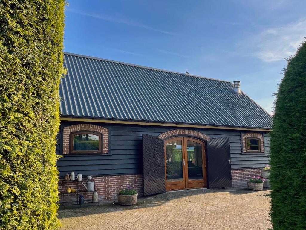 a blue building with a large door in front at 'Onze Knoerishoeve' in Odiliapeel