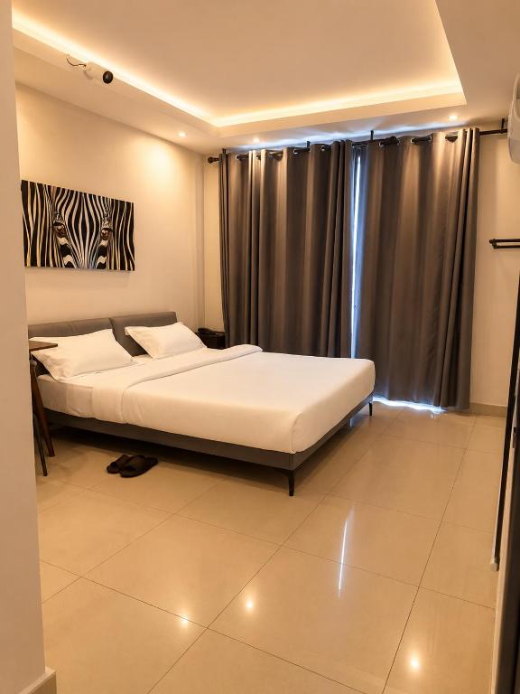 a bedroom with two beds in front of a window at The L Boutique Tz in Dar es Salaam