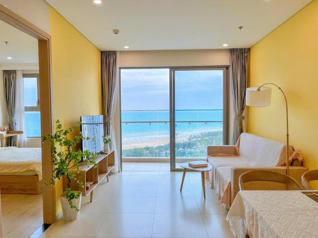 a hotel room with two beds and a large window at The Song Vung Tau Apartment - Căn Hộ Du Lịch Biển Vũng Tàu in Xã Thang Tam