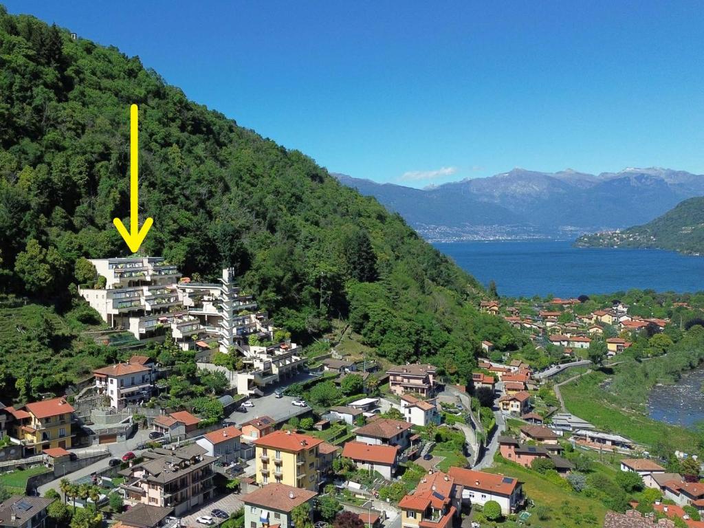 a town with a yellow arrow on top of a mountain at Appartamento Ato La Gerbia in Cannobio