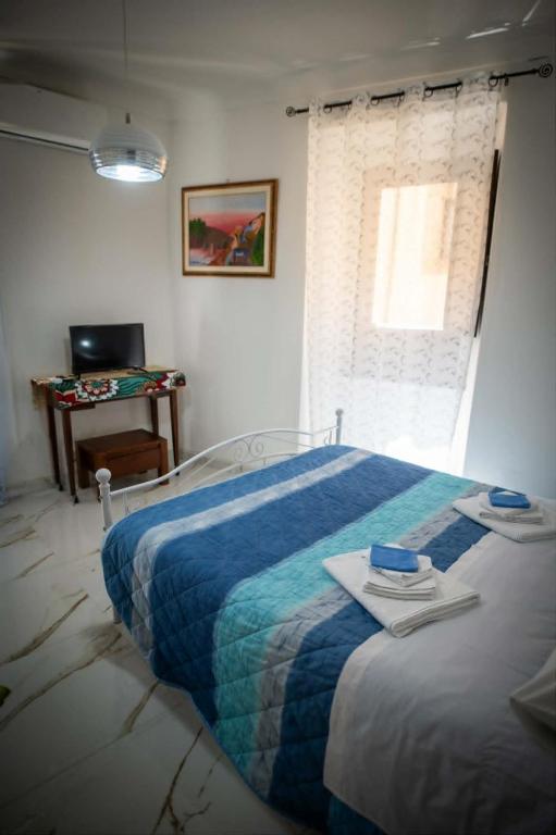a bedroom with a large bed and a window at Artemide B&B in Caltagirone
