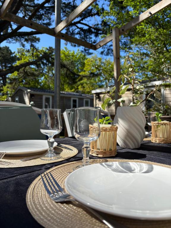 a table with a white plate and glasses on it at Sweet-Mobilhome21 in Fouesnant