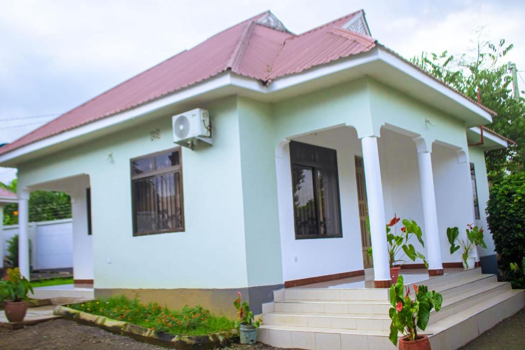 a small white house with a red roof at Chama Haven Appartment 2 bed in Tengeru