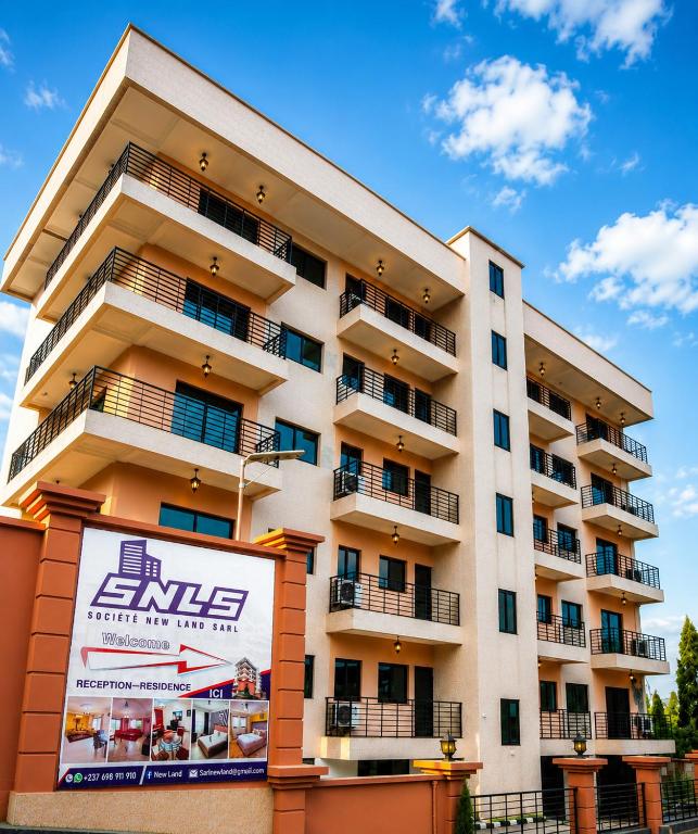 an apartment building with a sign in front of it at Newland Sarl in Douala