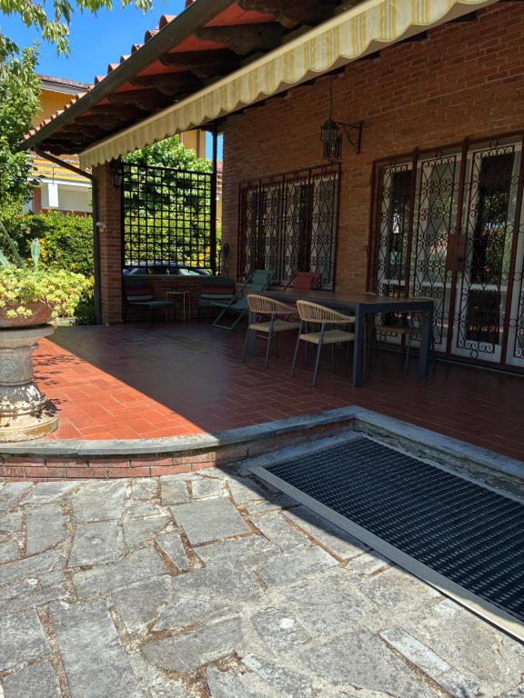 a patio with a table and chairs and a grill at Villa Feltran in Forte dei Marmi