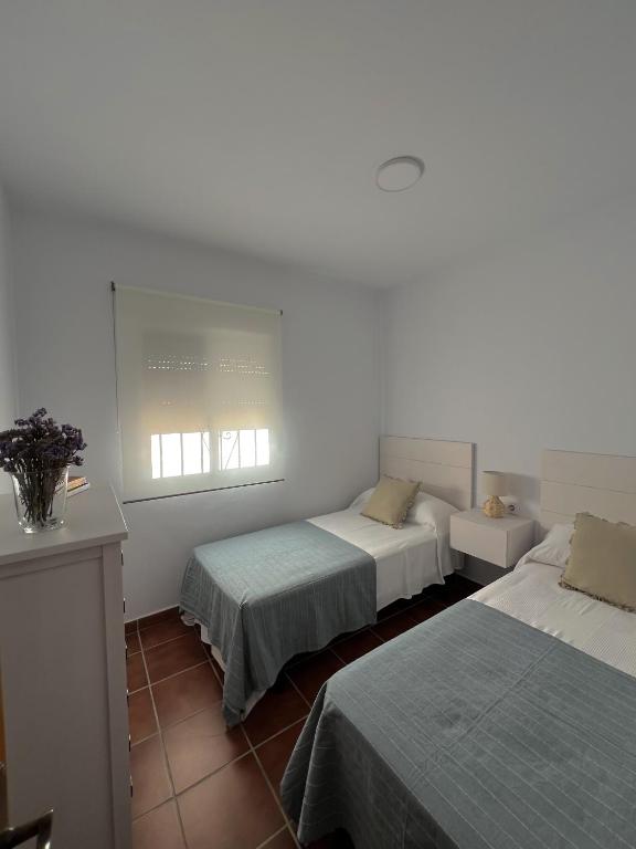 a bedroom with two beds and a window at Casa caminito 2 in Zahora