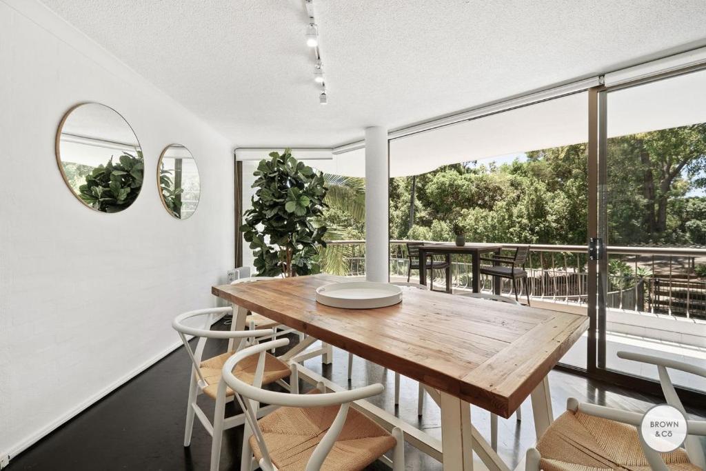 a dining room with a wooden table and chairs at Peggy - Little Cove in Noosa Heads