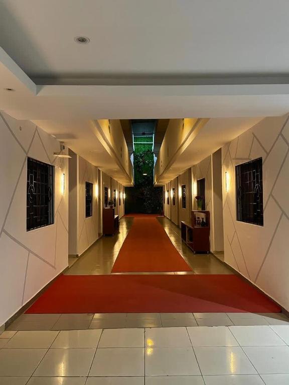 a hallway with a red carpet in a building at Hotel Nana in Abidjan