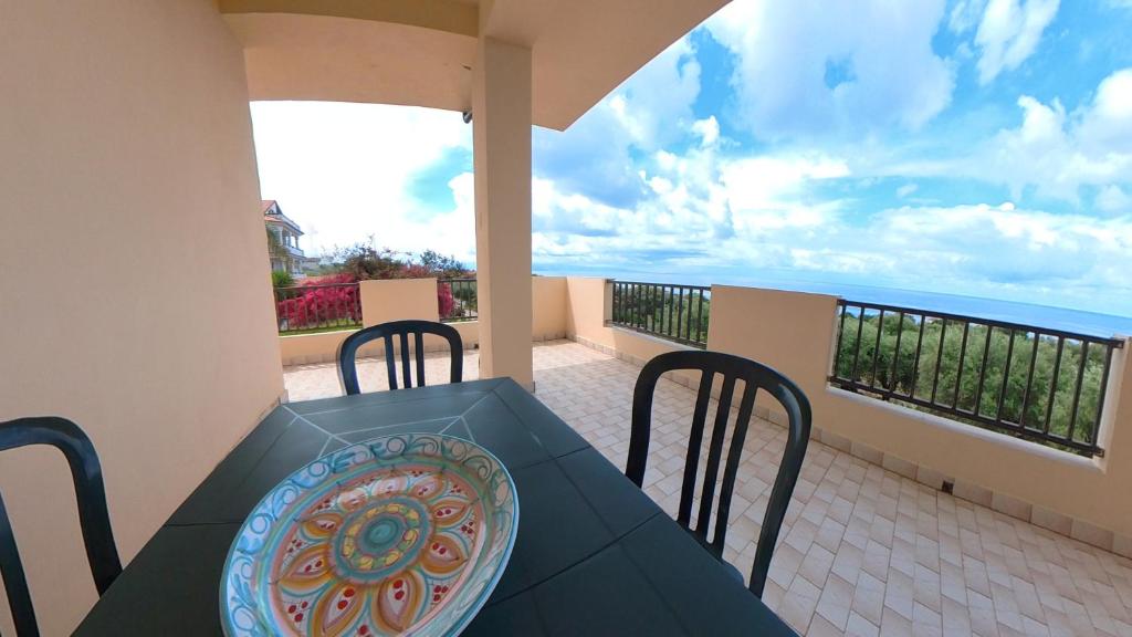 a table and chairs on a balcony with the ocean at La quiete dell'Ammiraglio 1 in Ioppolo