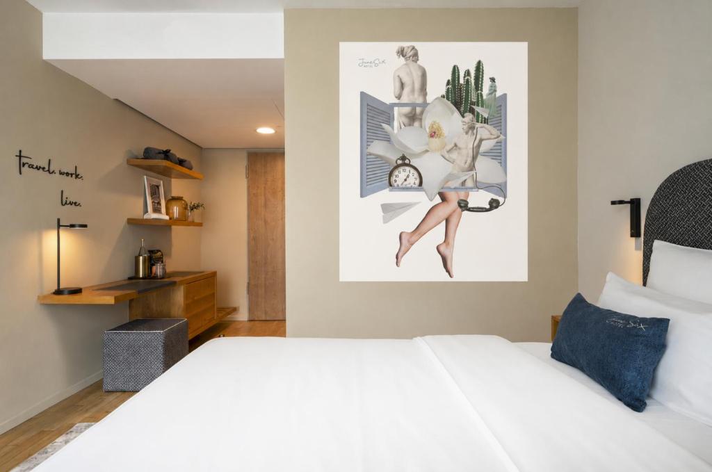 a bedroom with a white bed and a picture on the wall at June Six Hotel Berlin City West in Berlin