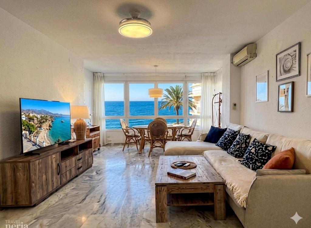 a living room with a couch and a tv and a table at Sunset Torrox Costa in Torrox
