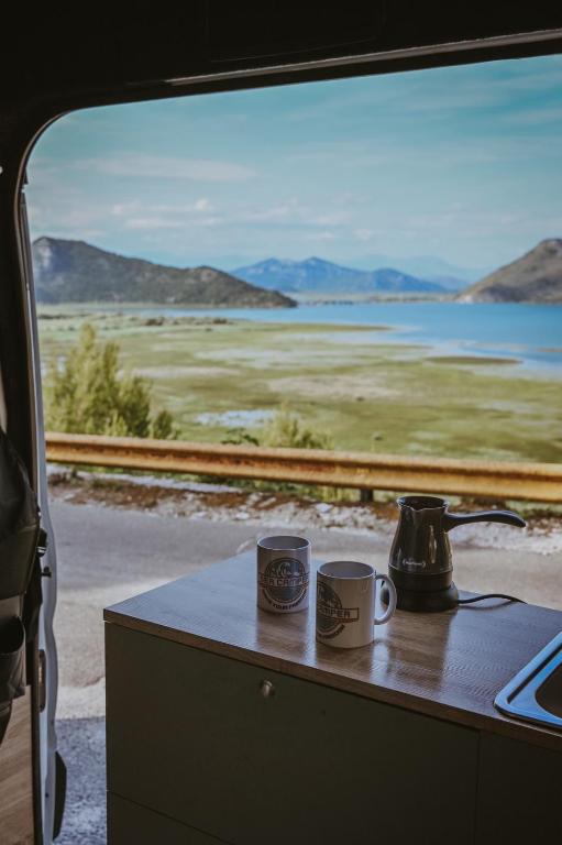 two coffee cups sitting on a table in a train car at Campervan Montenegro RV in Bar