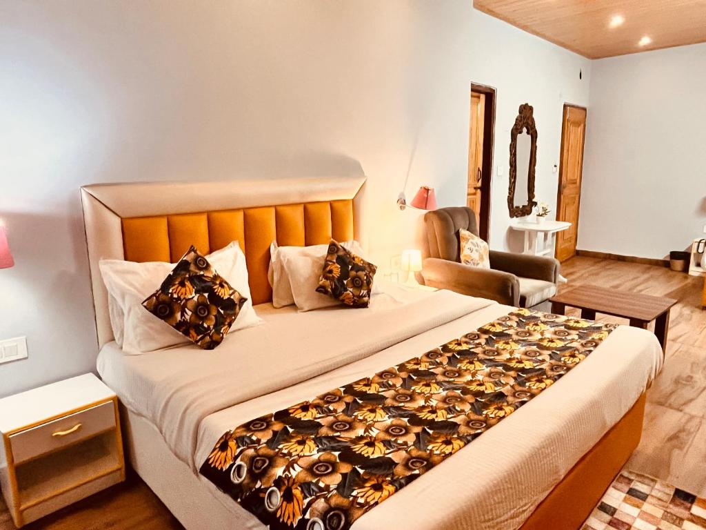 a bedroom with a large bed and a chair at Hadimba Palace, Manali in Manāli