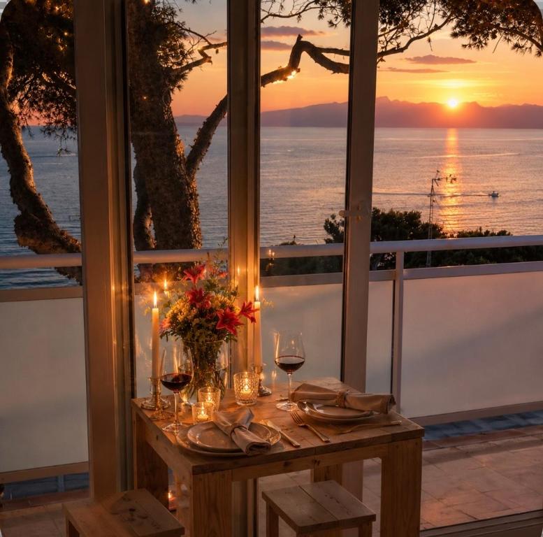 a table with glasses of wine and a view of the ocean at Apartamento con terraza y vistas al mar - Tree House Salou in Salou
