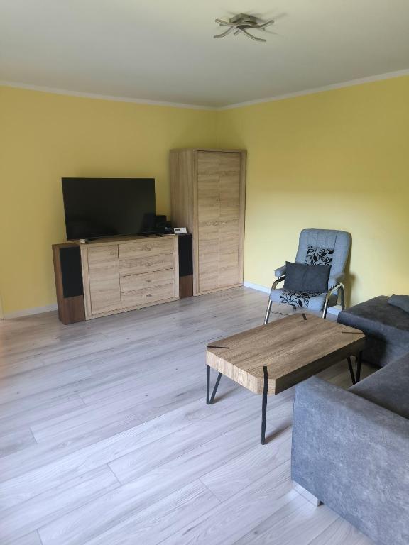 a living room with a couch and a table and a tv at Apartament Górna in Głuszyca
