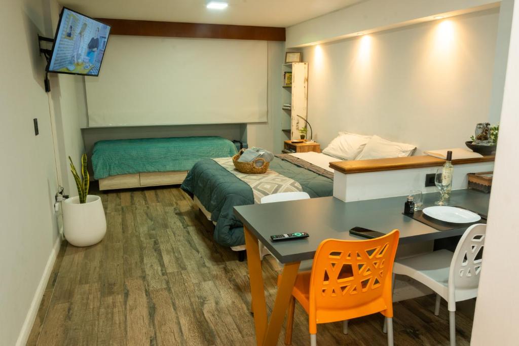 a bedroom with a bed and a desk and a table at Estudio Lino in Córdoba