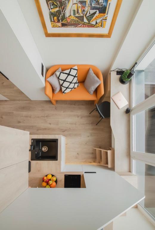 a small room with an orange couch in the attic at Cosy apartment in Vilnius