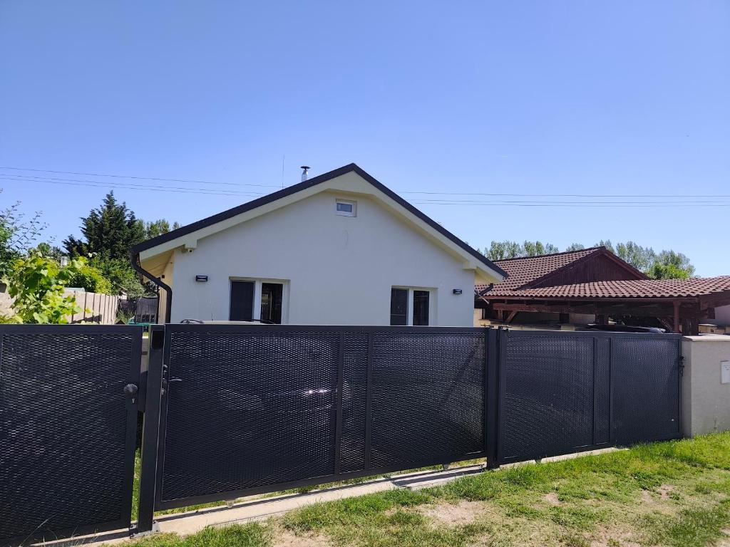 a white house behind a black fence at Villa de Calma Samorin in Šamorín