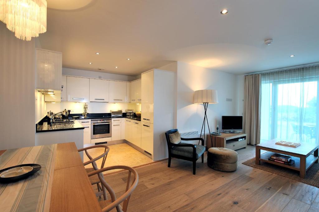 a kitchen and living room with a table and chairs at St Moritz Hotel and Cowshed Spa in Polzeath