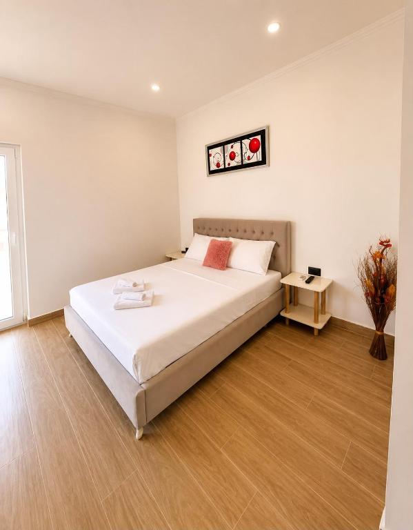 a bedroom with a large white bed and a table at PRIAM Beach Borsh in Borsh