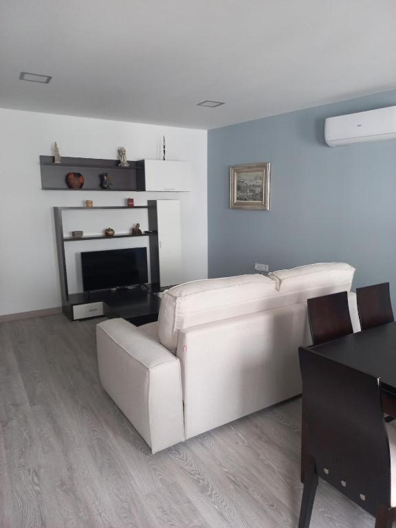 a living room with a white couch and a fireplace at Casa de la Soledad 3 in Lugo