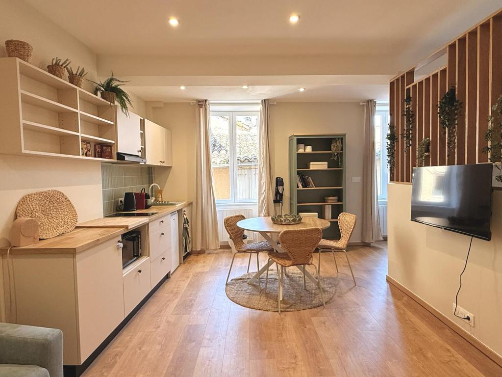 a kitchen with a table and chairs in a room at Le Stervin in Villefranche-sur-Saône