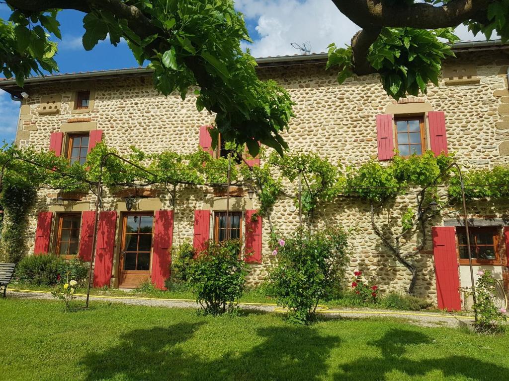 an old stone building with red shutters on it at Domaine Mariedal in Hauterives