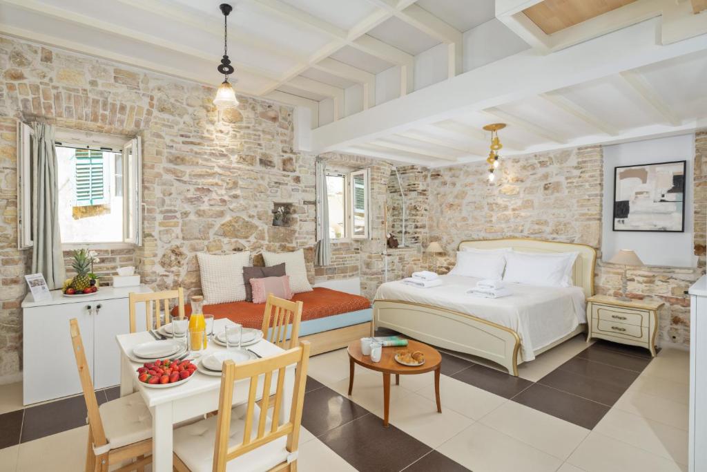 a bedroom with a bed and a living room at Corfu Breeze Liston Apartments in Corfu