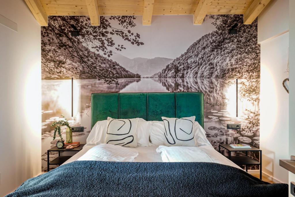a bedroom with a large bed with a green headboard at Alpine Lodge Green by Tss - Downtown, classy in Levico Terme