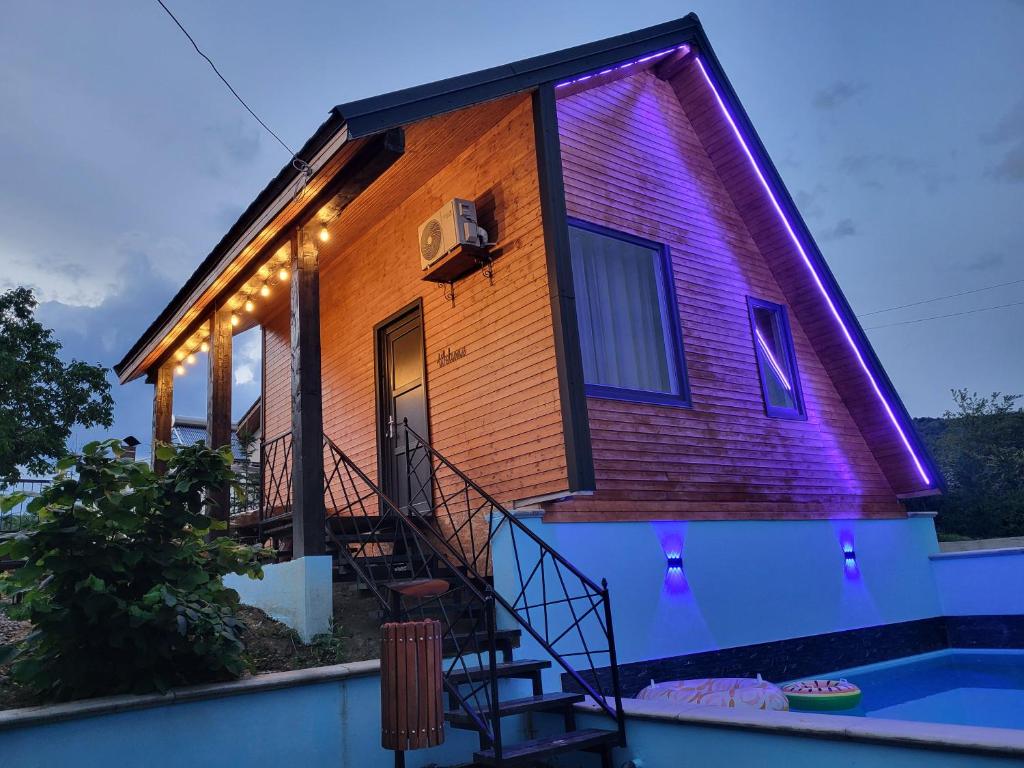 a house that is lit up with purple lights at All4you Chalet Călimănești in Jiblea Veche