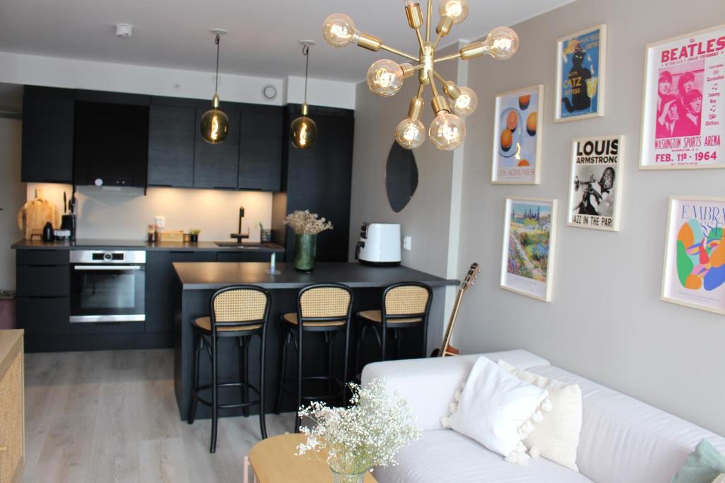 a living room with a white couch and a kitchen at Moderne toppleilighet i Bergen in Bergen