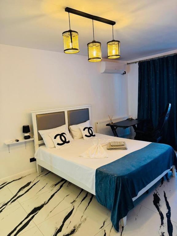 a bedroom with a large bed with two chandeliers at Apartament Plaja Neversea in Constanţa