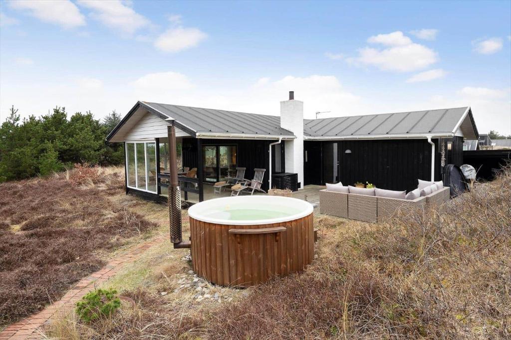 a house with a hot tub in the yard at 1115-Ringkobing-Nordsovej-466 in Søndervig