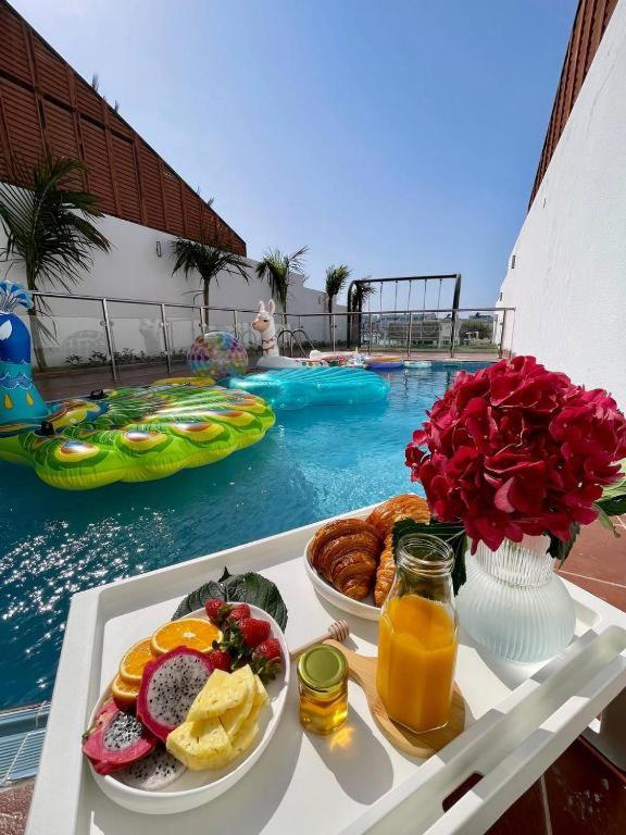 a tray of food on a table next to a pool at Rose Beach 7 درة العروس in Jeddah