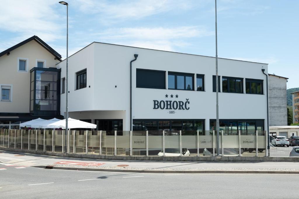 a white building with a sign that reads booit at Superior Rooms Bohorč in Šentjur