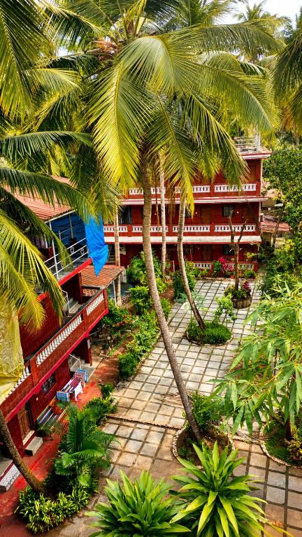 a group of palm trees in front of a building at selfia guest house in Majorda
