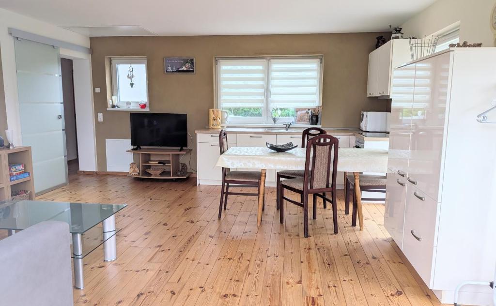 a kitchen with a table and chairs in a kitchen at Ferienwohnung Gartenblick in Fuhlendorf