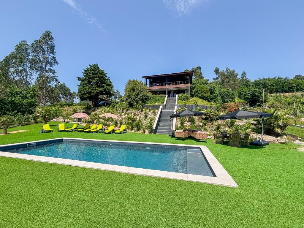 a house with a swimming pool and green grass at Abadia House - Geres in Geres
