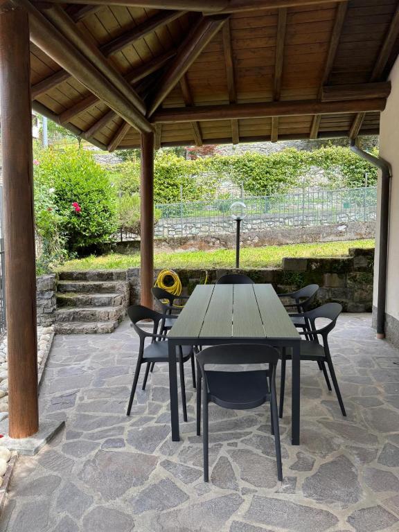 a wooden table and chairs on a patio at La casa di Ernesto in Carlazzo