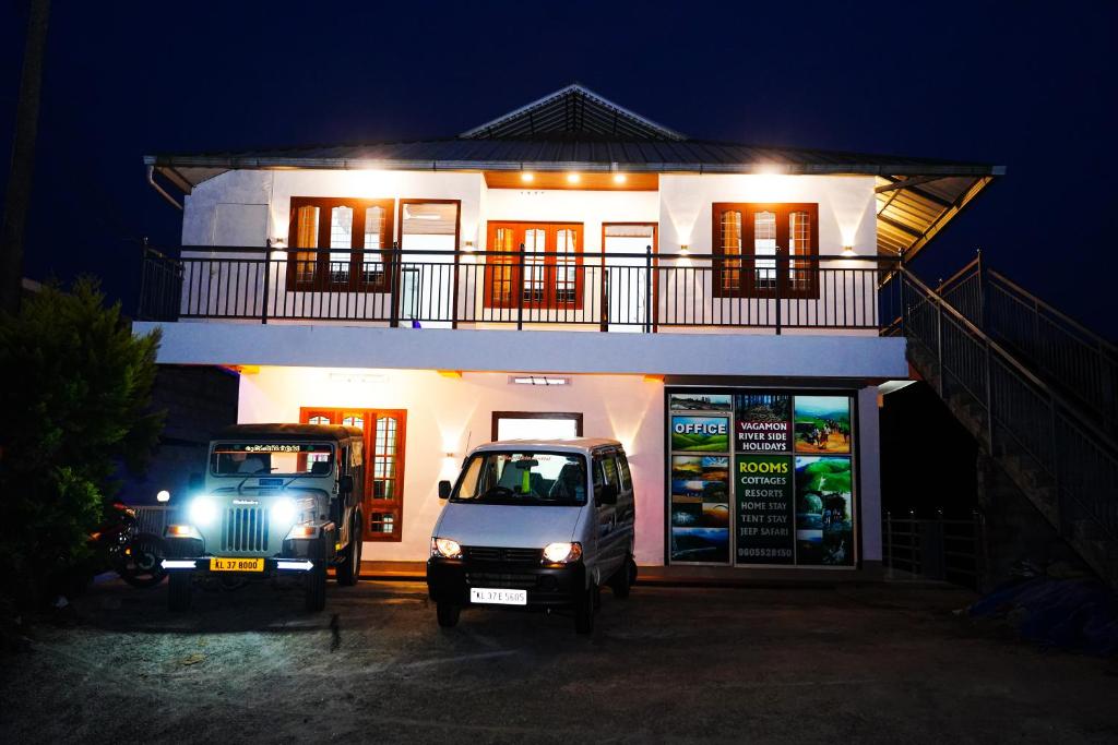 two vehicles parked in front of a house at night at River side in Vagamon