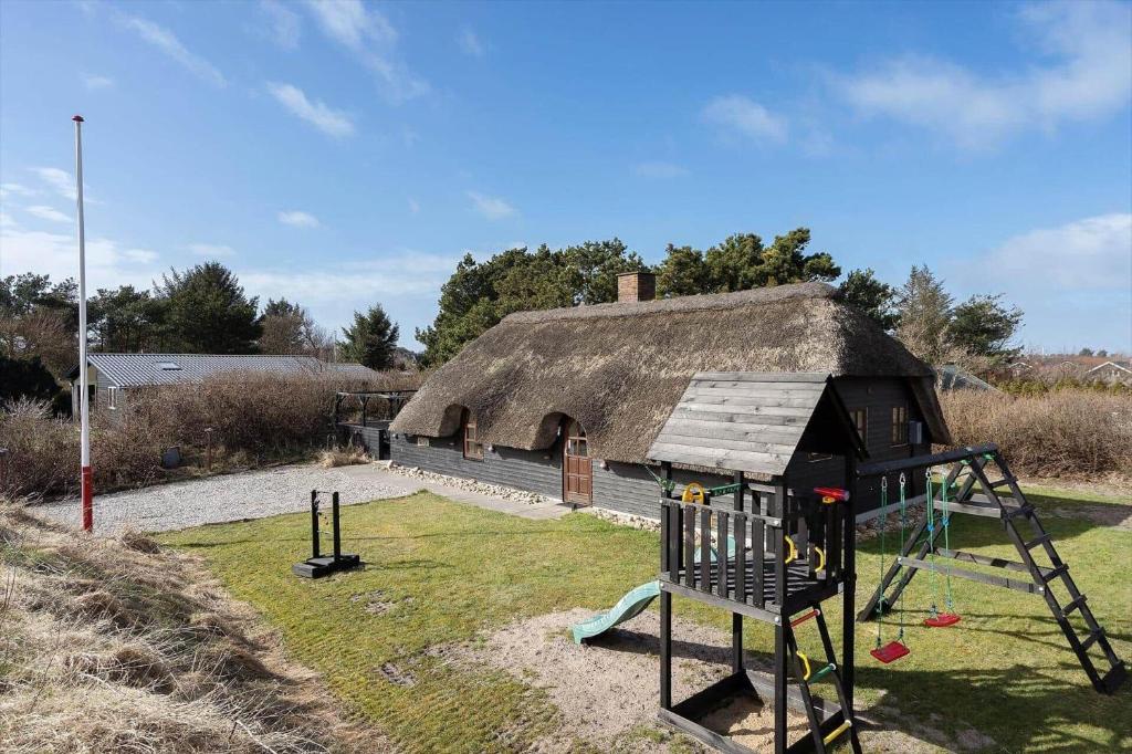 a playground in front of a thatched building at 068-Ringkobing-Hvidbjergvej-4 in Søndervig