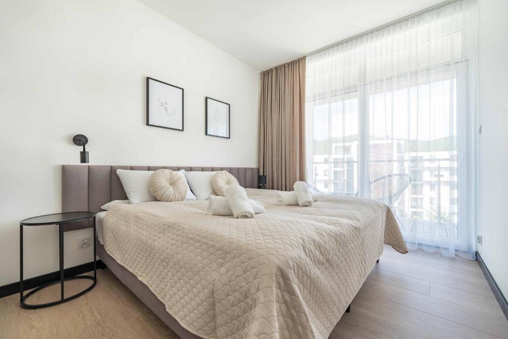 a bedroom with a large bed and a large window at Apartament Panorama Pod Dębowcem in Bielsko-Biała