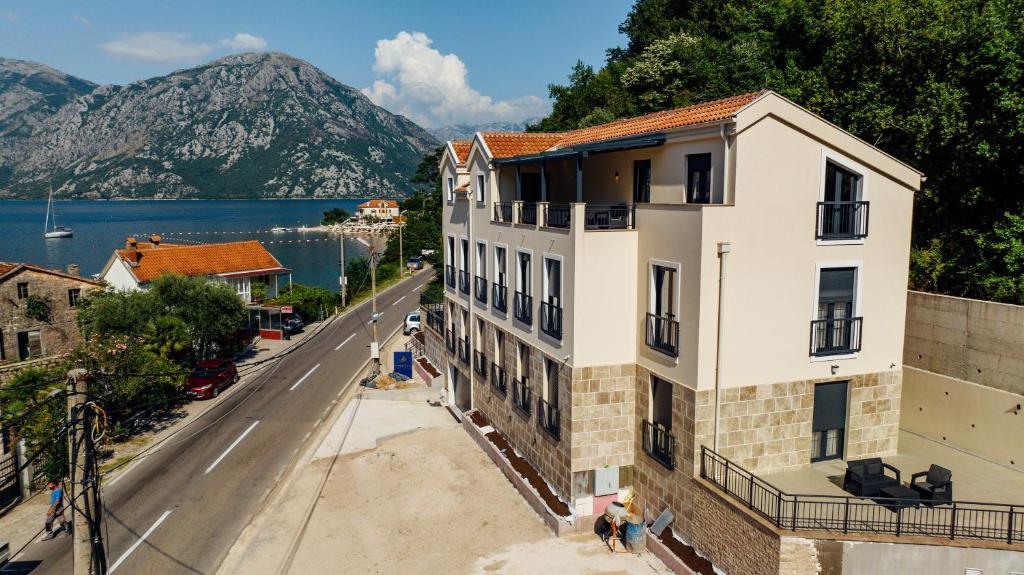 ein Gebäude an einer Straße neben einem See in der Unterkunft Amalia in Donji Morinj