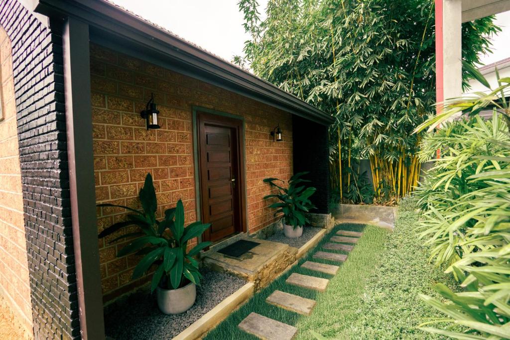 a brick house with a door and some plants at Yamu Lanka Inn in Malabe