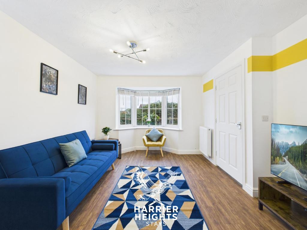 a living room with a blue couch and a tv at Spacious 5 Bed Contractor Hub 3 Baths Corby in Corby