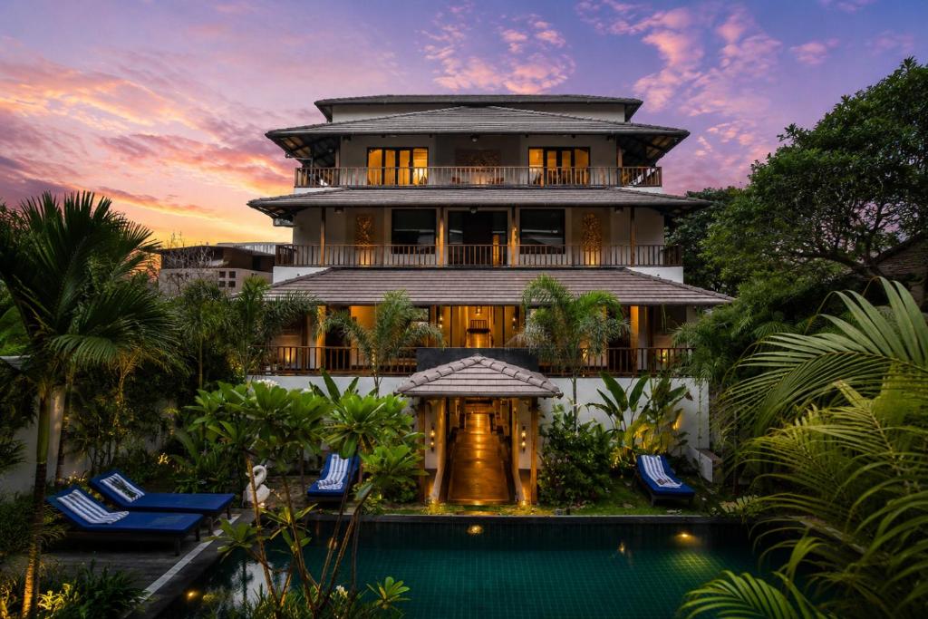 a house with a swimming pool in front of a building at Anantya At Anamiva in North goa