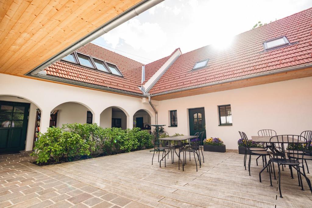 an outdoor patio with tables and chairs and a roof at Geigenhof in Neudorf bei Ilz