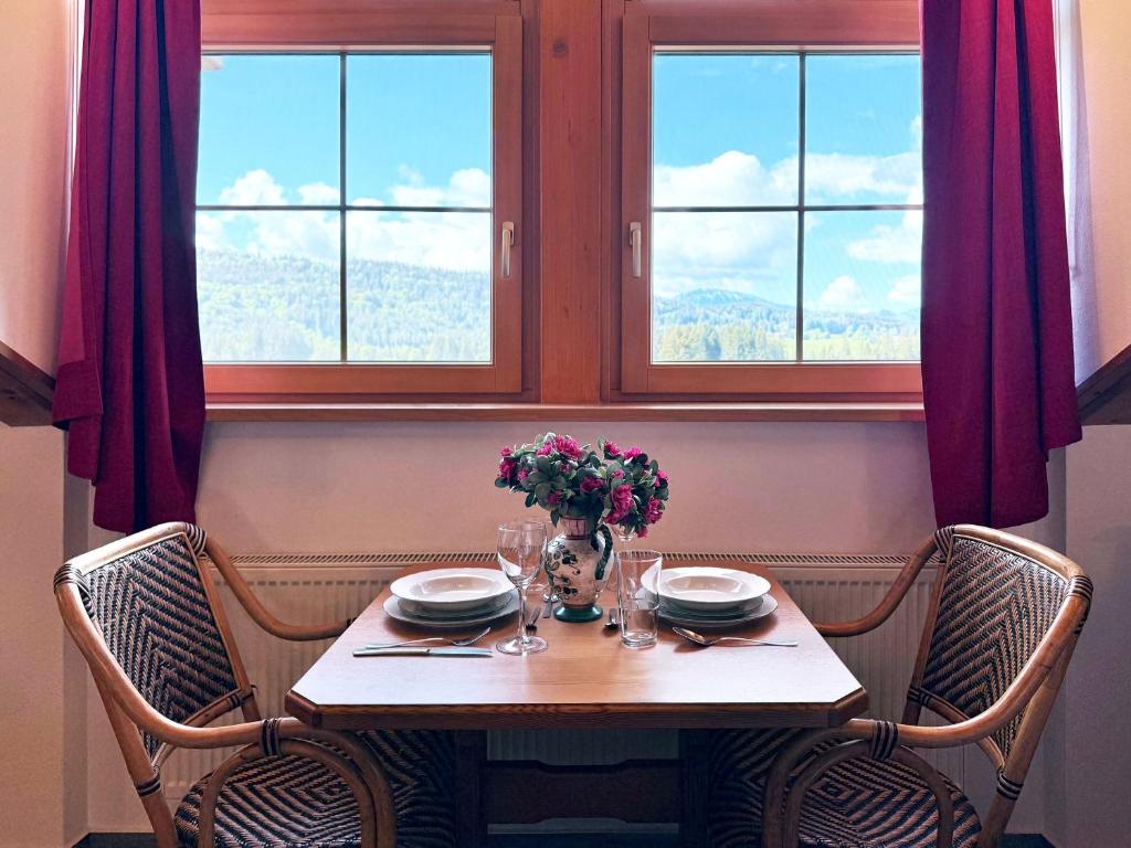 a table with chairs and a vase of flowers on it at Sonnenhof Seeg 15 in Seeg